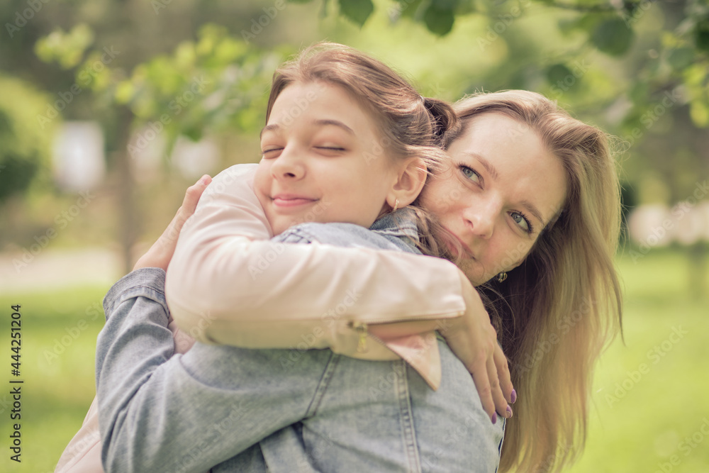 happy mother with her daughter hugging a teenager in the summer. Caring happy mother enjoy day with teenage girl child, laugh have fun. Mother giving her daughter advice. happy mother with her daughter hugging a teenager in the summer. Caring happy mother enjoy day with teenage girl child, laugh have fun. Mother giving her daughter advice.