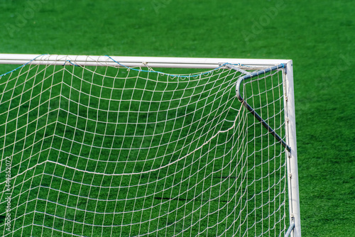 Fragment of a football goal against the background of a green field