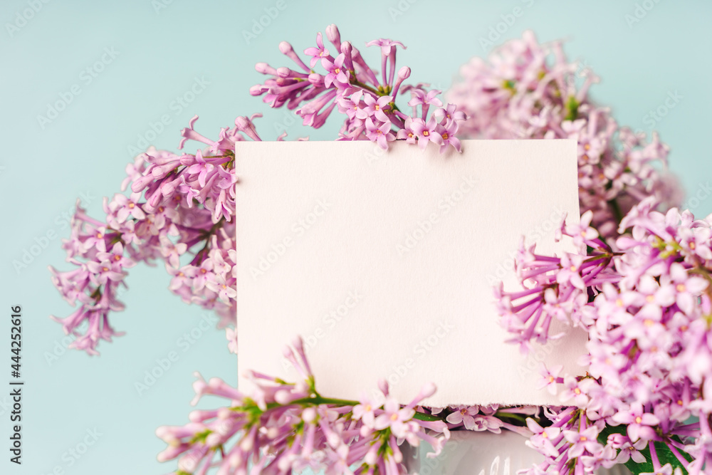 A beautiful floral composition and an empty paper notepad for text. Floral spring background with lilac. Copy space