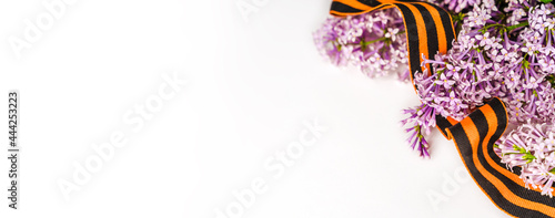 Beautiful floral background with St. George ribbon and lilac. Spring holiday banner with a place for the text photo