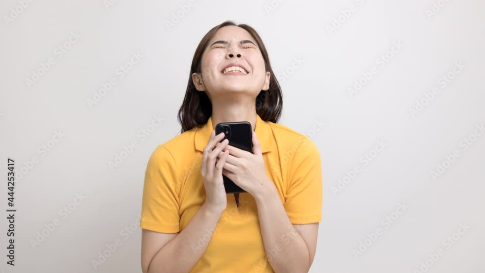 Pretty young asian woman using smartphone standing on isolated white background. She texting on cell phone. Pretty young asian woman using smartphone standing on isolated white background. She texting on cell phone.