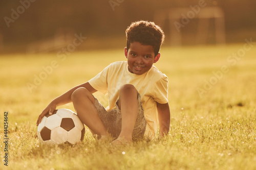 Beautiful sunshine. African american kid have fun in the field at summer daytime