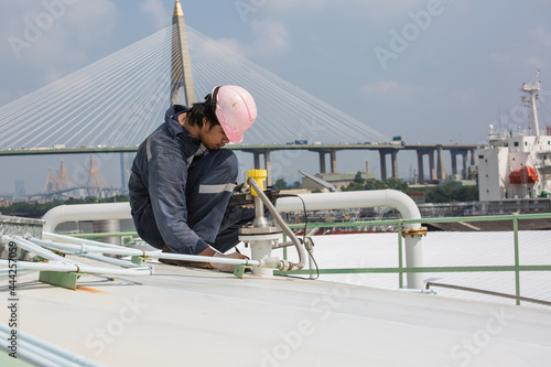 Male worker are ultrasonic thickness roof of  storage tank