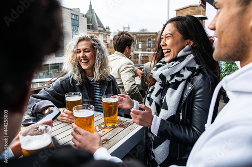 Tablou pe pânză People enjoying a beer together at pub brewery - Happy laughing man and women ta