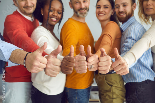 Group of different senior and young people giving thumbs up. Dream team of smiling friends, colleagues or business partners doing like gesture, hands closeup. Satisfaction, successful teamwork concept photo