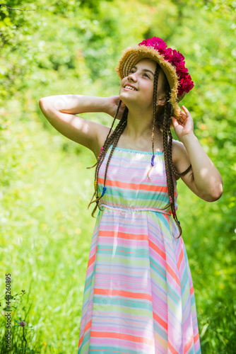 happy kid girl in straw hat with rose flowers in summer nature  childhood