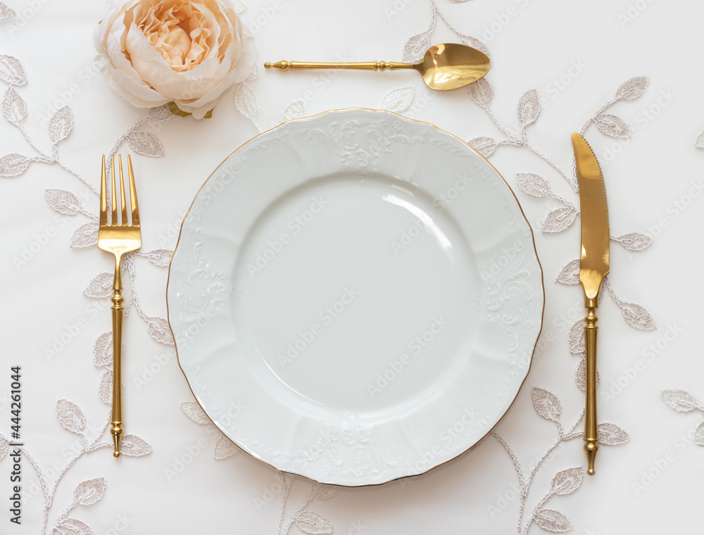 Wedding table arranged with golden cutlery and white charger plate. Mockup  for menu, invitation card, festive concept in vintage style Stock Photo