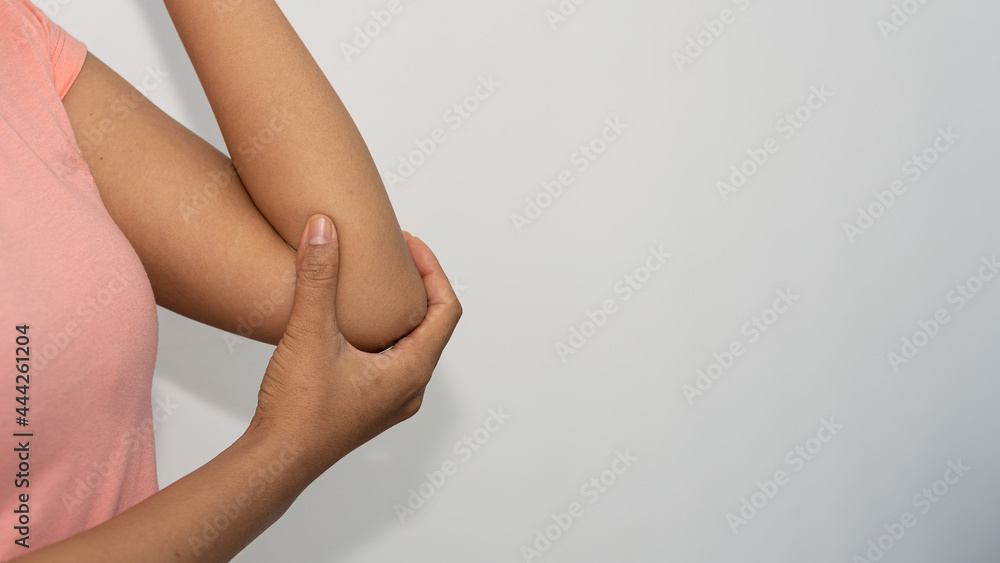 Young woman with pain in elbow and clenched hand holding a medical concept
