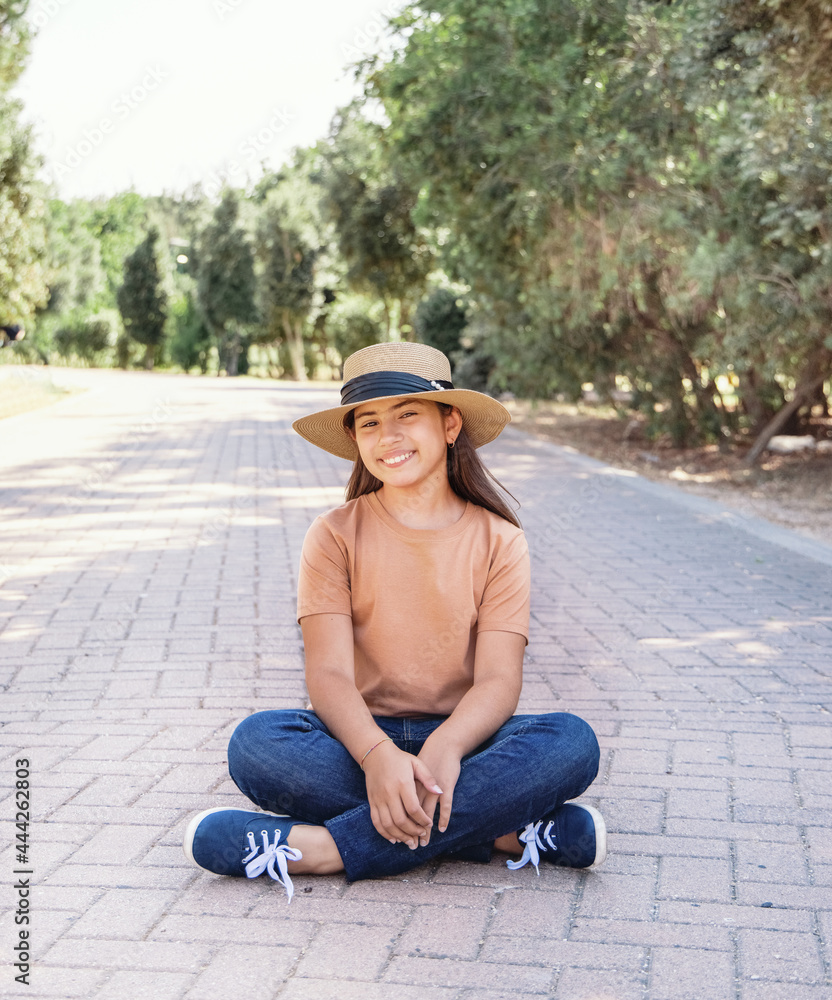 Smiling girl kid wearing t-shirt; jeans and straw hat