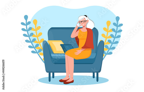 Grey elderly woman is talking on the phone from home