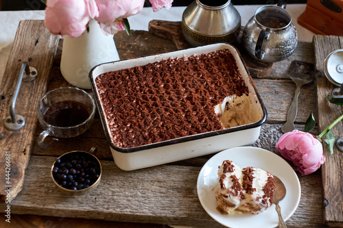 Homemade tiramisu. Peonies, coffee, blueberries. Side view. photo