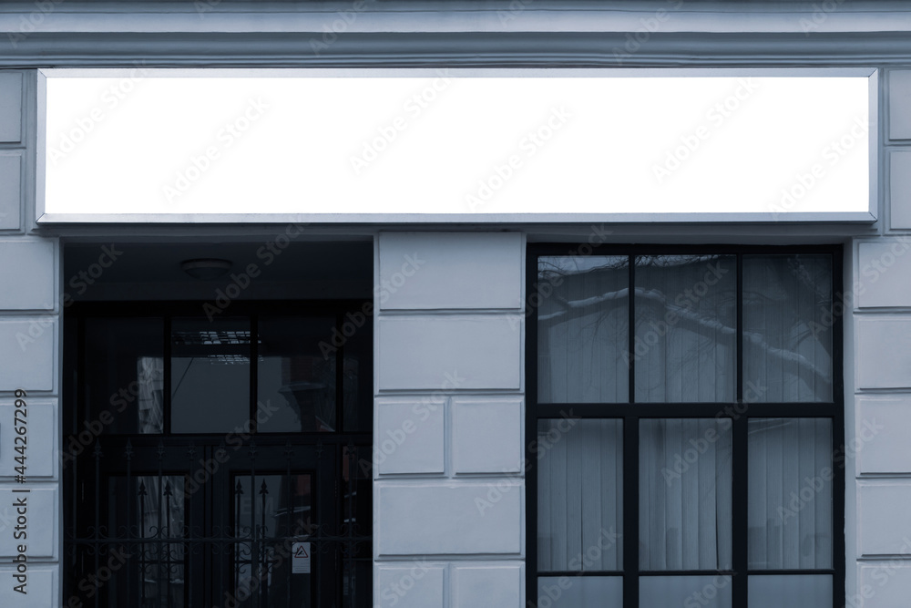 Fototapeta premium Close-up of a masonry building with a blank advertising banner above the window