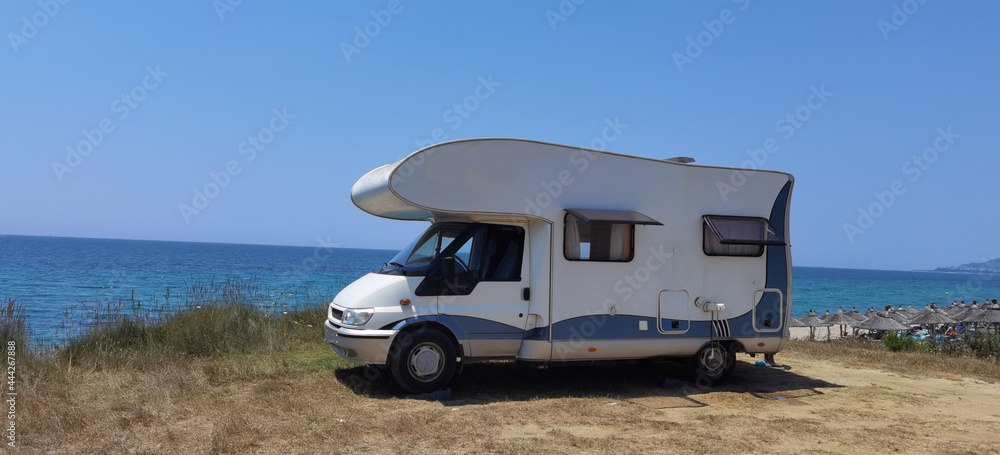 caravan car by the sea in summer beach trees blue sky