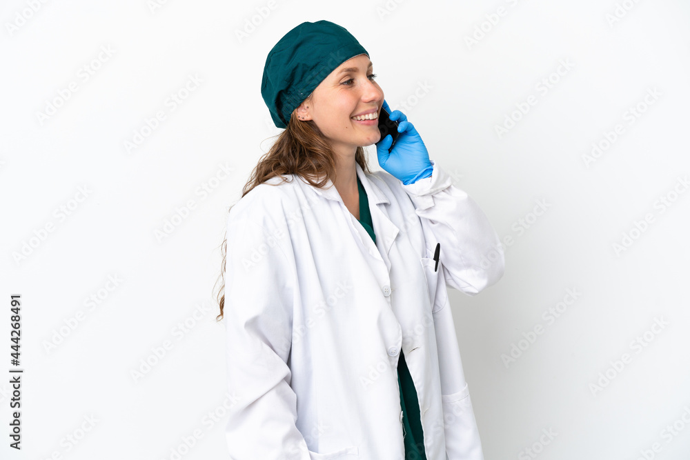 Surgeon caucasian woman in green uniform isolated on white background keeping a conversation with the mobile phone Surgeon caucasian woman in green uniform isolated on white background keeping a conversation with the mobile phone