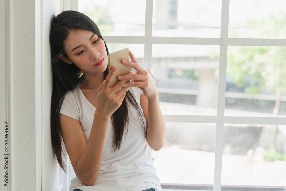 portrait of a woman playing smartphone cellphone in bedroom on morning portrait of a woman playing smartphone cellphone in bedroom on morning