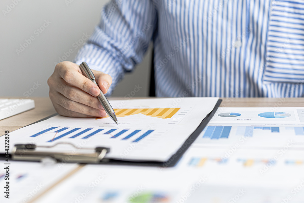 A businesswoman is reviewing the sales summary sheet from the sales department, she is reviewing the data and analyzing the sales data to plan to manage more sales growth. Sales management concept. A businesswoman is reviewing the sales summary sheet from the sales department, she is reviewing the data and analyzing the sales data to plan to manage more sales growth. Sales management concept.