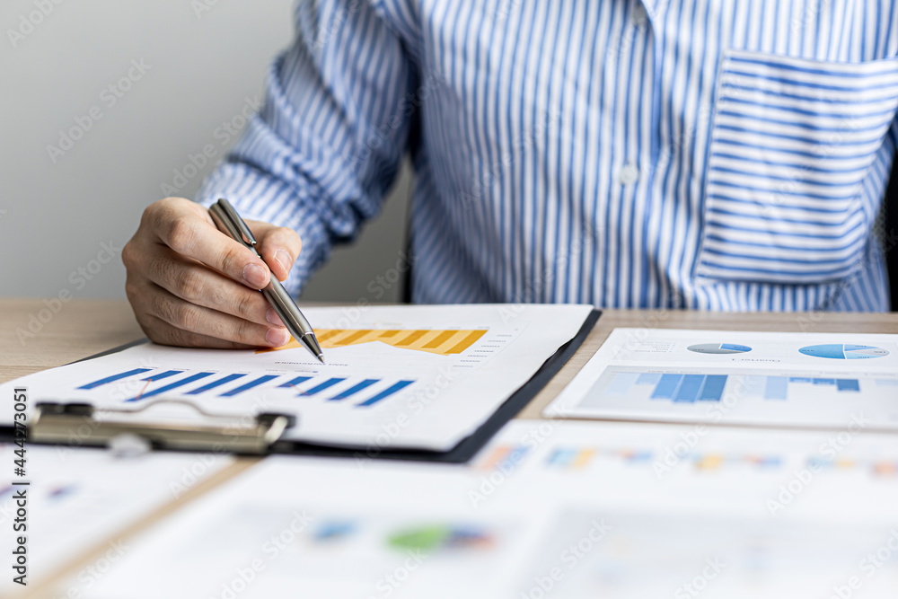 A businesswoman is reviewing the sales summary sheet from the sales department, she is reviewing the data and analyzing the sales data to plan to manage more sales growth. Sales management concept. A businesswoman is reviewing the sales summary sheet from the sales department, she is reviewing the data and analyzing the sales data to plan to manage more sales growth. Sales management concept.