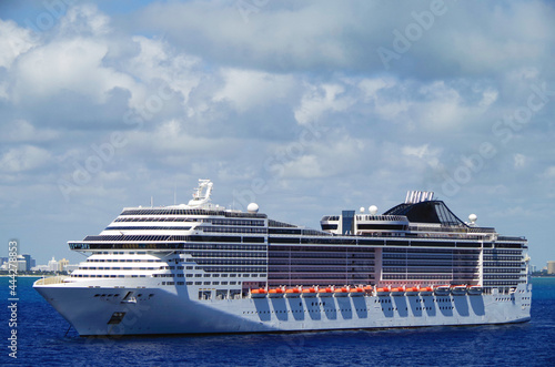 Big modern MSC Cruises cruiseship or cruise ship liner Divina anchoring out of Port of Miami, Florida skyline and skyscrapers in background waiting for passengers for Caribbean cruising holiday	 photo