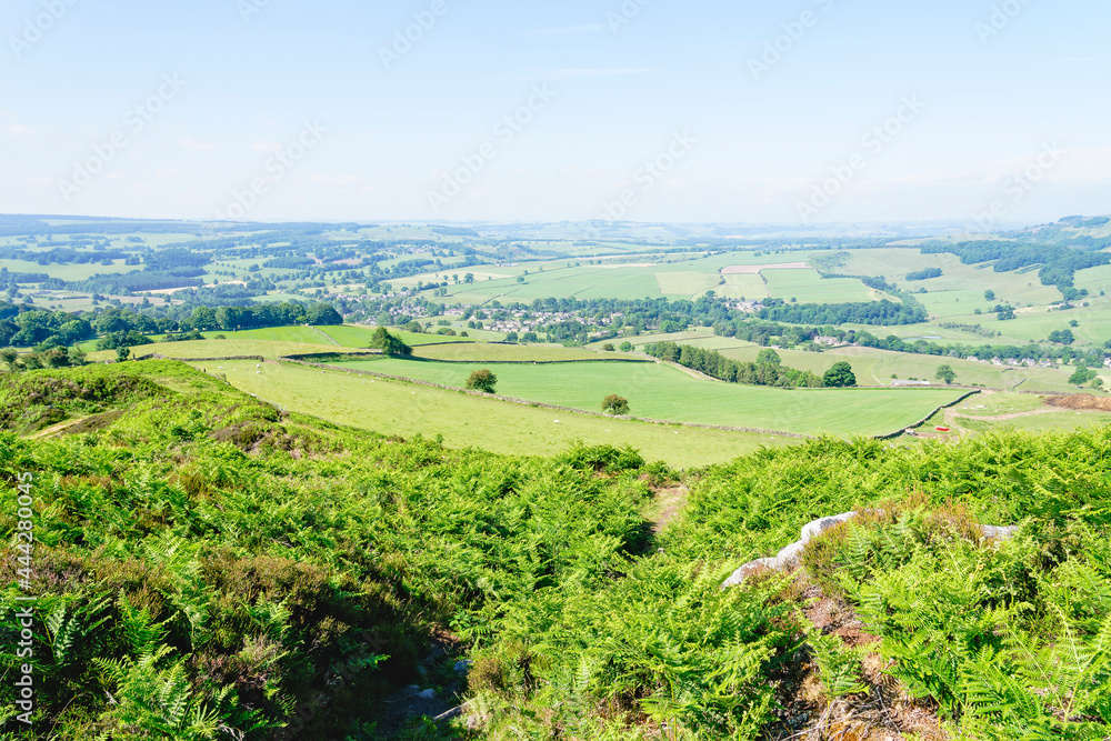 Down the steep heather covered slopes of Baslow Edge to a misty Derbyshire countryside