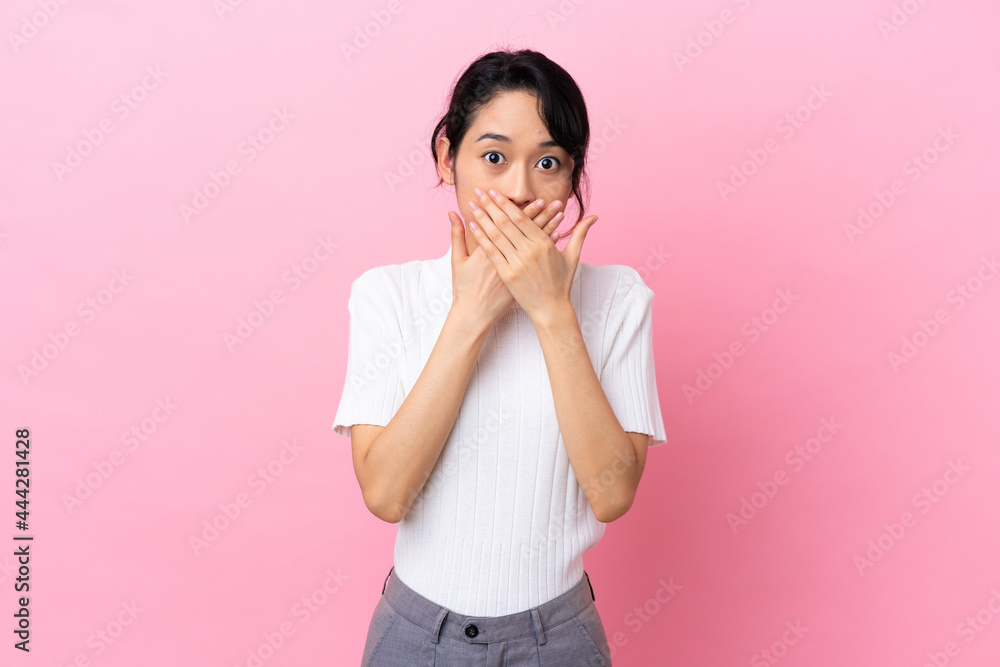 Young Vietnamese woman isolated on pink background covering mouth with hands Young Vietnamese woman isolated on pink background covering mouth with hands