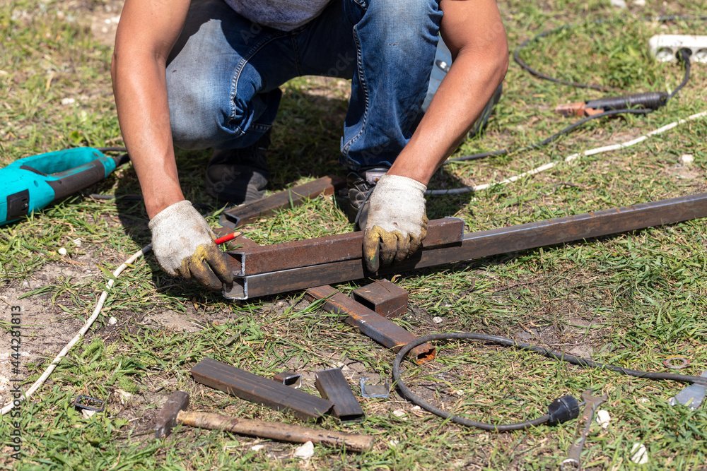 Worker cut metal pipes at a house construction site. Worker cut metal pipes at a house construction site.