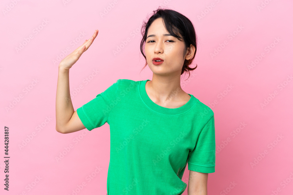Young Vietnamese woman isolated on pink background with tired and sick expression Young Vietnamese woman isolated on pink background with tired and sick expression