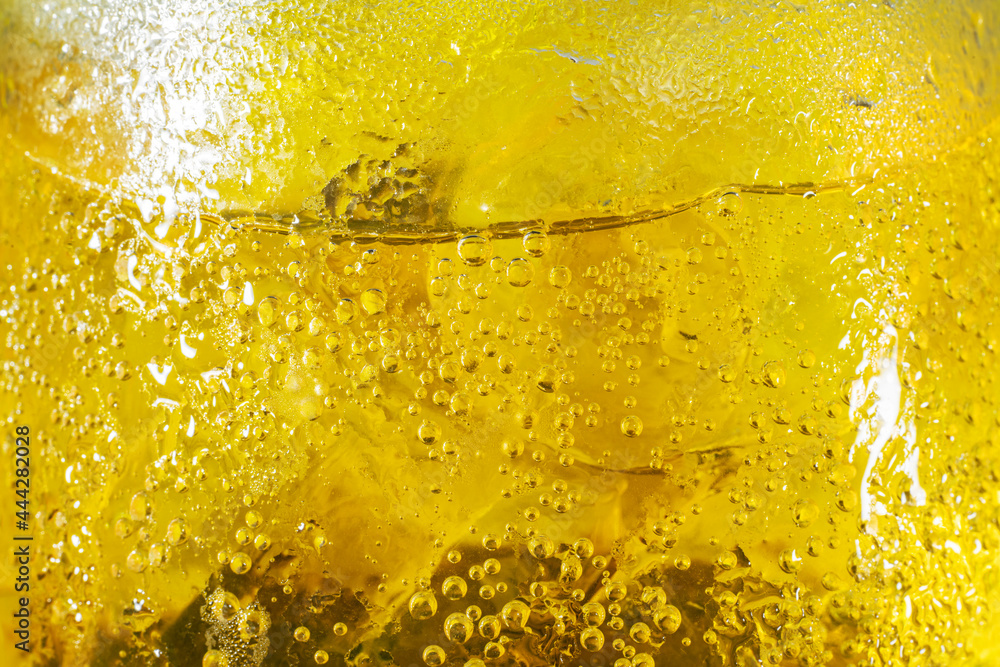 Yellow bubble of water on ice in a glasses beer or whisky. background texture. Yellow bubble of water on ice in a glasses beer or whisky. background texture.