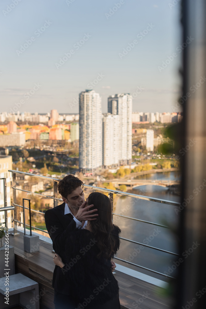 man kissing woman on roof of restaurant man kissing woman on roof of restaurant