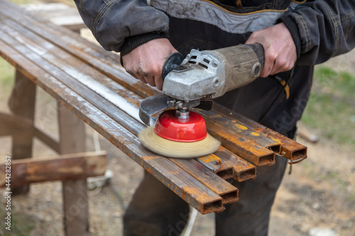 A worker grinds metal at a construction site.