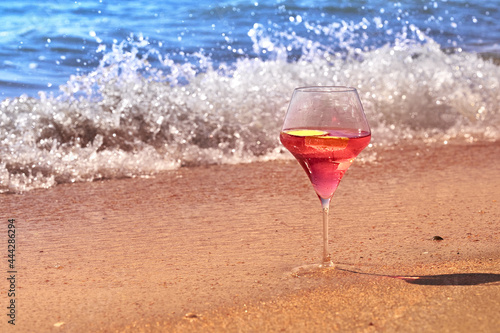 Wine glass with a cocktail by the sea.