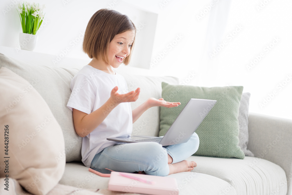 Photo portrait little girl sitting on couch talking on web camera Photo portrait little girl sitting on couch talking on web camera