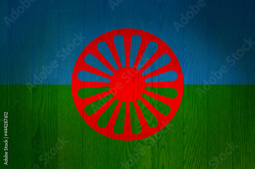 Romani flag on a grunge wooden background. Gypsy flag.