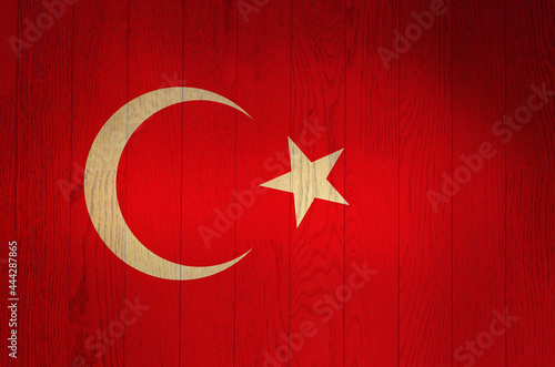 The flag of Turkey on a grunge wooden background.