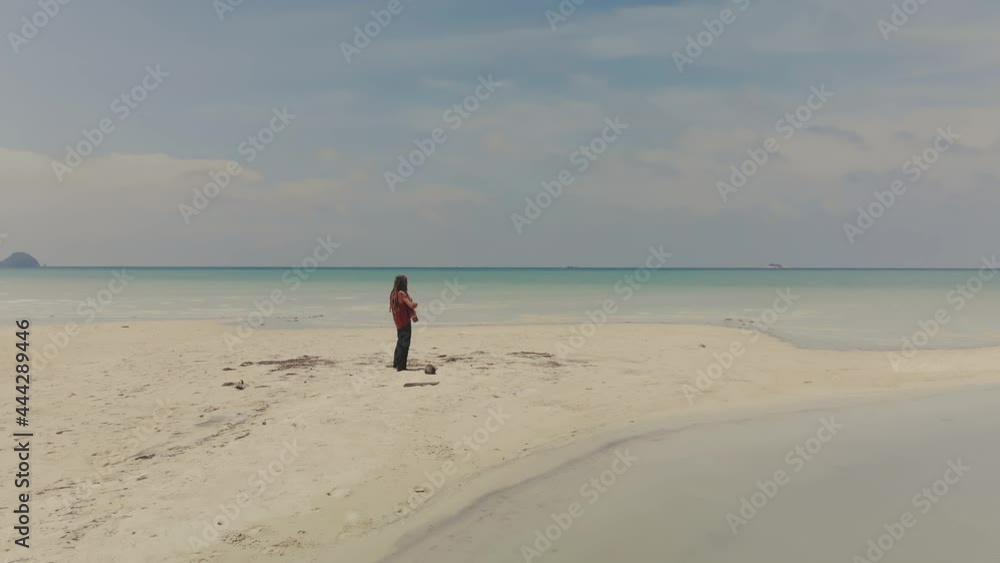 man with dreadlocks playing guitare on seascape- drone view man with dreadlocks playing guitare on seascape- drone view