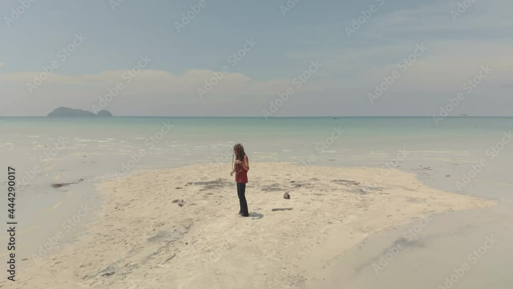 man with dreadlocks dancing and singing on seascape- drone view man with dreadlocks dancing and singing on seascape- drone view