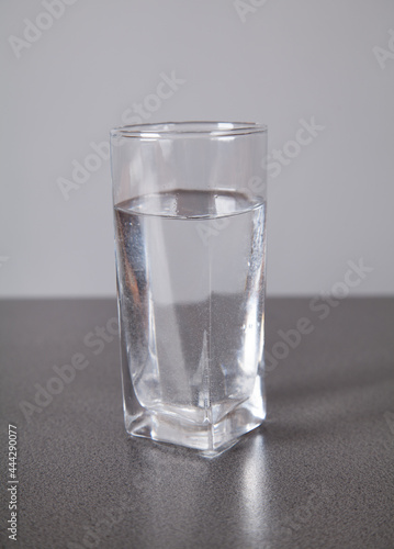 Water with glass, on gray background.