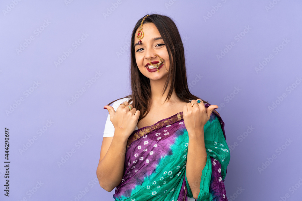 Young Indian woman isolated on purple background with thumbs up gesture and smiling Young Indian woman isolated on purple background with thumbs up gesture and smiling