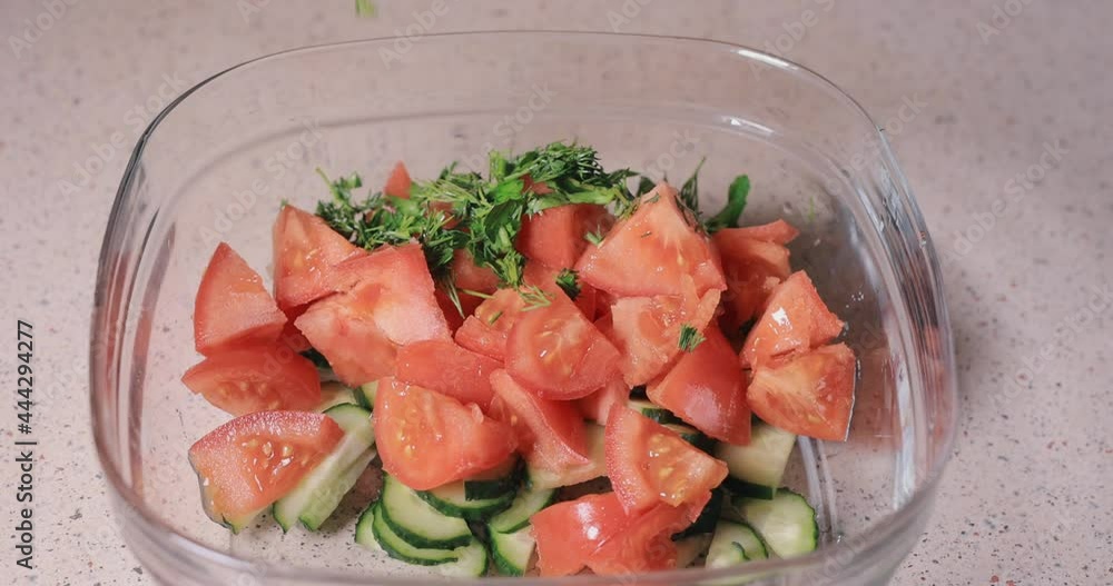 Pouring dill and parsley into the bowl, making salad Pouring dill and parsley into the bowl, making salad