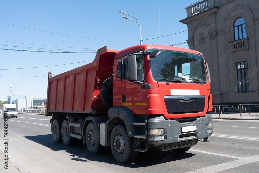Red lorry at the city crossroads. Freight transport equipment in the city. Red lorry at the city crossroads. Freight transport equipment in the city.