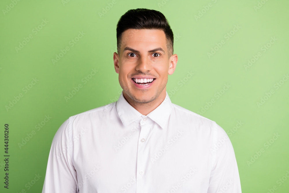 Photo of impressed charming young gentleman wear white shirt big eyes smiling isolated green color background Photo of impressed charming young gentleman wear white shirt big eyes smiling isolated green color background