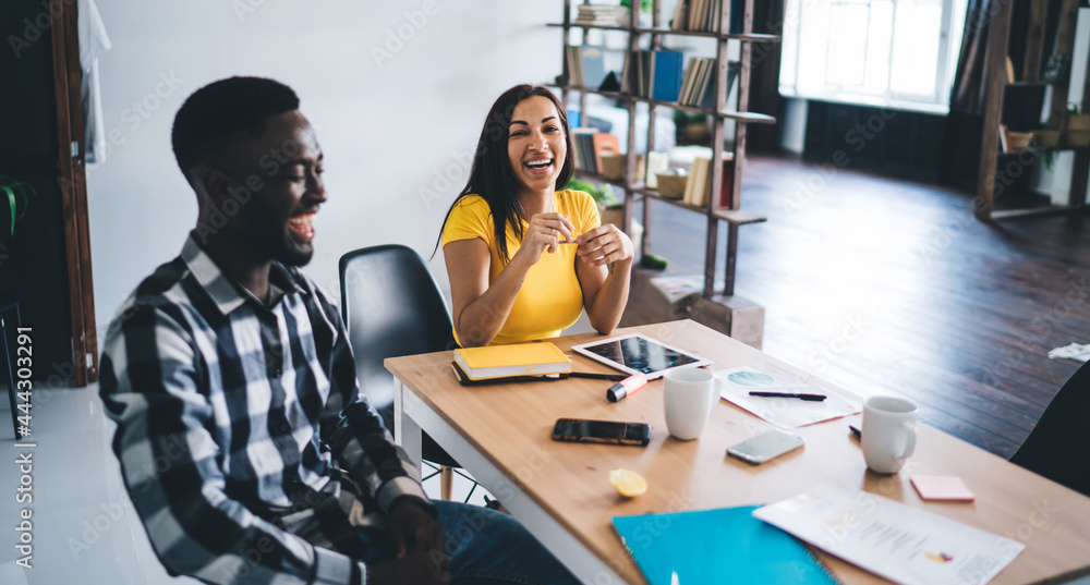 Happy diverse coworkers communicating at table Happy diverse coworkers communicating at table