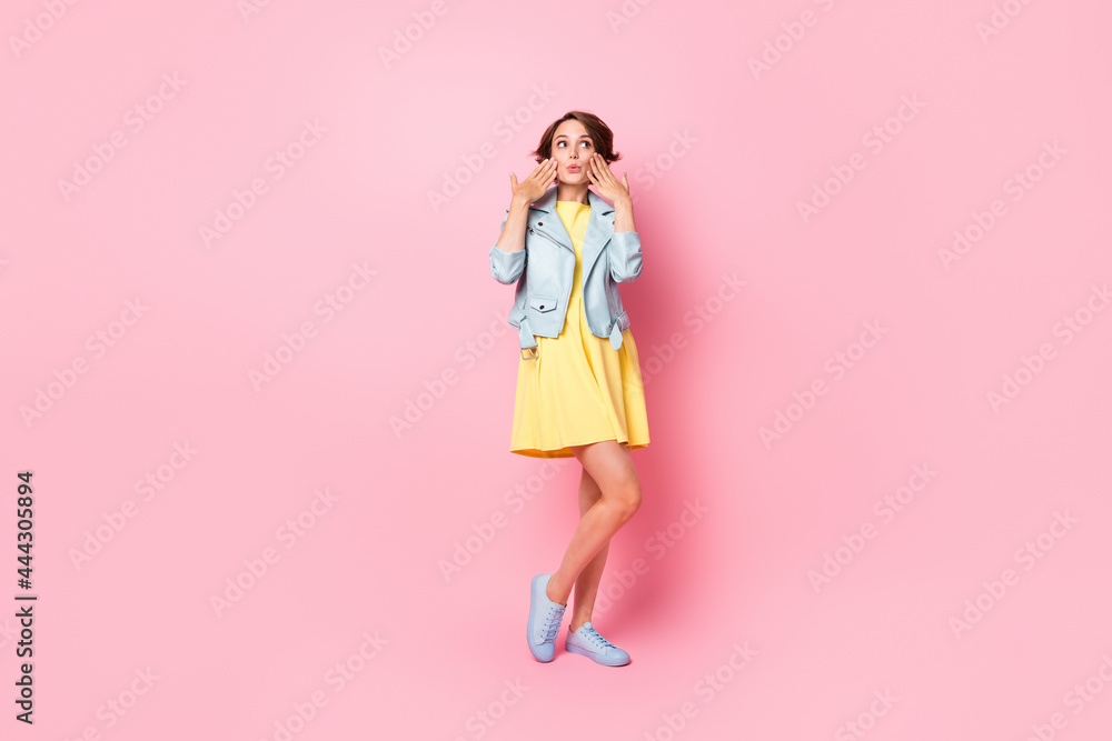 Full length photo of charming impressed young lady wear teal leather jacket arms cheeks isolated pink color background Full length photo of charming impressed young lady wear teal leather jacket arms cheeks isolated pink color background