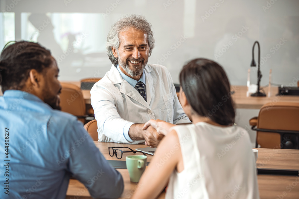 Obraz premium Doctor shaking hands with woman. Female patient visiting health professional. They are in hospital. Cropped shot of a handsome mature male doctor and his patient shaking hands in the hospital
