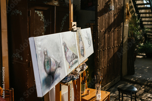 Pigeons painting on canvas on easel in workshop photo