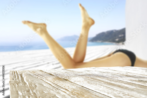 Desk of free space and slim young woman in bikini 