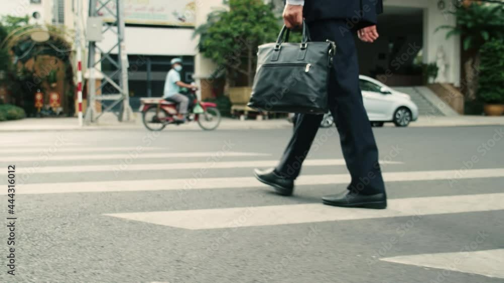 Close up rear view of a hurry aucasian middle aged business man in leather shoes and suit on the way to the office building,businessman in a suit crosses the road on a zebra crossing, man gets to work Close up rear view of a hurry aucasian middle aged business man in leather shoes and suit on the way to the office building,businessman in a suit crosses the road on a zebra crossing, man gets to work