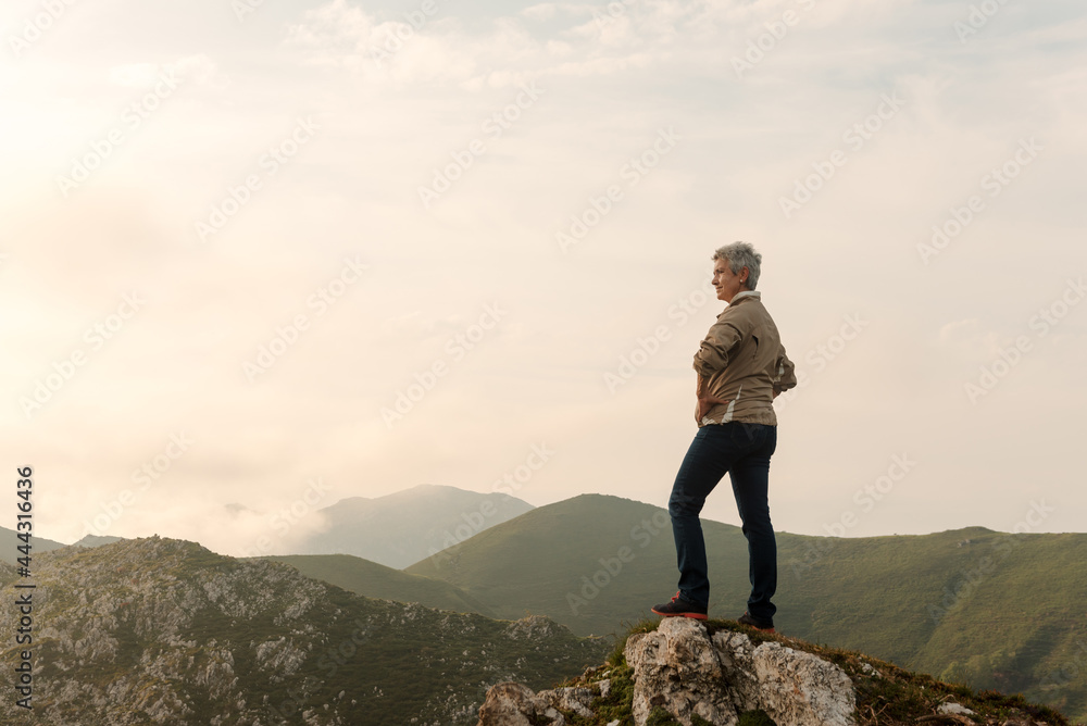 Senior woman traveler in mountains at sunrise Senior woman traveler in mountains at sunrise
