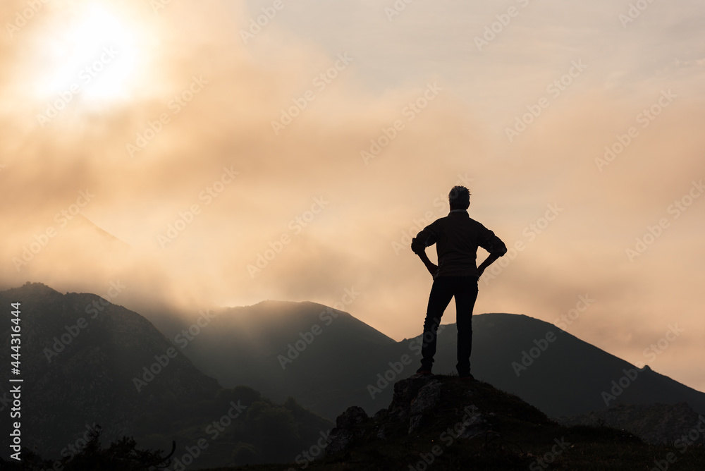 Unrecognizable traveler in mountains at sunrise Unrecognizable traveler in mountains at sunrise