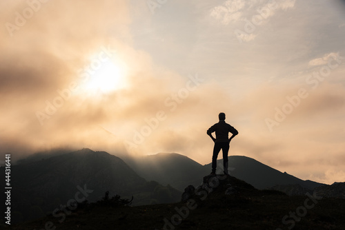 Unrecognizable traveler in mountains at sunrise