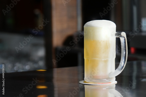 delicious mug of super cold and refreshing draft beer on the table in the blurred background photo